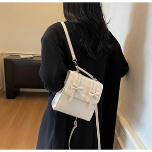 Creamy bow crossbody bag shown on model with chic Korean style and plaid pattern detail