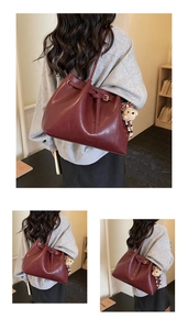 Détail du sac cabas bordeaux avec fermeture à cordon et joli pendentif ours en peluche