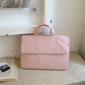 Pink quilted laptop bag detail with thick handles and a front flap pocket for storage