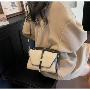 Détail du sac à main vintage en toile et cuir avec boucle dorée et bandoulière réglable