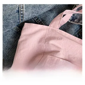 Close-up of pink nylon tote bag showing soft pleated fabric texture and stitching