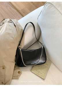 Détail du sac sous le bras noir avec texte NO FILTER et chaîne argentée chic