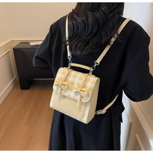 Close-up of yellow plaid pattern with bow details on a stylish PU leather small backpack