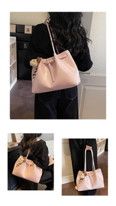 Détail du sac cabas en cuir rose avec texture fine et petit ours en peluche attaché