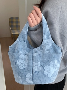 Blue floral embroidered tote bag with dual front pockets and large capacity design