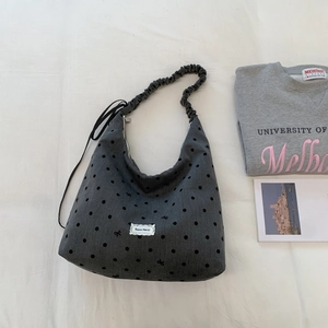 Close-up of gray polka dot canvas tote with ruffled strap and lace Beyou Merci label