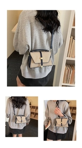 Détail du sac en toile avec surpiqûres en cuir, bandoulière réglable et boucle dorée