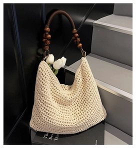 Detail of hand-woven beige tote with dark wooden beads and braided shoulder strap