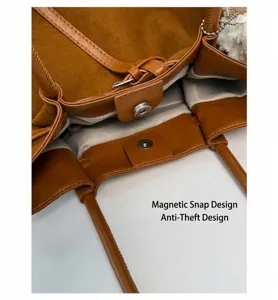 Detail of warm brown leather tote featuring a round magnetic clasp and wave pattern lining