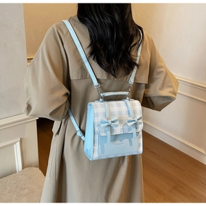 Detail of light blue checkered backpack with decorative bows and adjustable straps