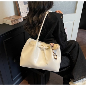 Détail du grand sac cabas crème avec lanière en cuir et pendentif peluche mode rétro