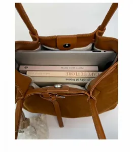 Top view of large capacity brown tote bag with suede lining holding laptop and books