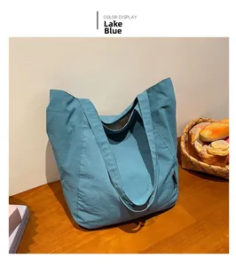 Detail of lake blue canvas tote bag showing wide shoulder straps and striped lining