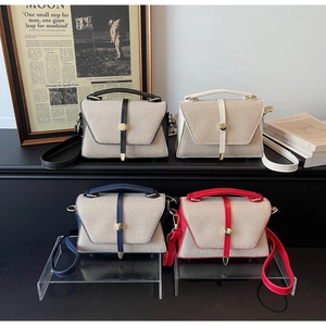 Gros plan de sacs à bandoulière en patchwork élégants en quatre couleurs sur un support