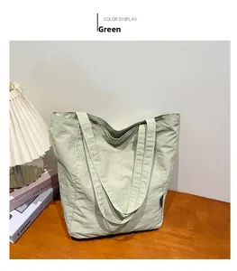 Detail view of the light green nylon tote bag on a wooden table with home decor