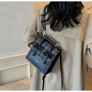 Model wearing a plaid bow-knot crossbody bag with a trench coat in a stylish back view