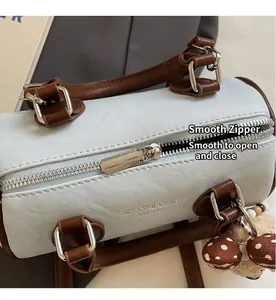 Close-up of smooth silver zipper and leather handles on a light blue pillow bag