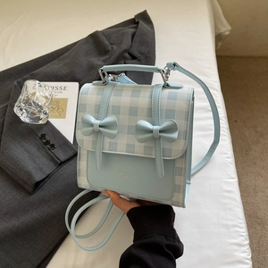 Close-up of blue and white plaid mini backpack featuring delicate bow accents