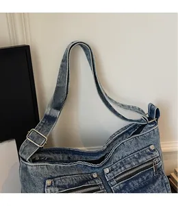 Close-up of adjustable strap and metal buckle on washed blue denim tote bag