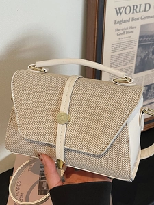 Sac à main tissé chic avec bordure en cuir blanc et boucle dorée présenté en mode de vie