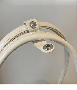Detailed macro view of the cream leather handle and silver magnetic snap closure