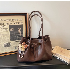 Vue détaillée du sac cabas vintage marron foncé avec boucle en cuir et breloque ours
