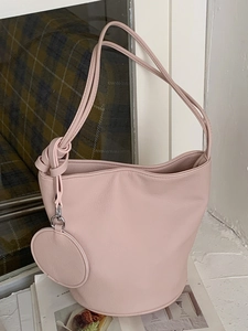 Sac seau chic en cuir rose avec porte-monnaie rond assorti et bandoulières nouées