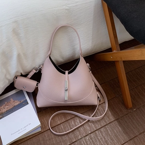 Detail of light pink pebble leather bucket bag with silver metal buckle and mini pouch