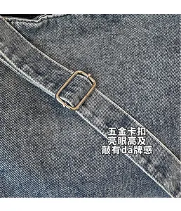 Detail of silver square metal buckle and blue denim fabric on large tote bag