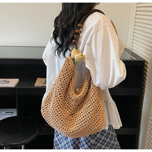 Detail view of woven crochet tote bag with dark brown wood bead shoulder strap accents