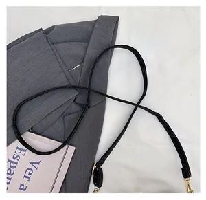 Detail of the slim black PU leather shoulder strap with elegant gold metal lobster clasps