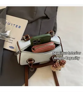 Spacious interior of two-tone pillow bag showing phone, wallet and cute plush charm
