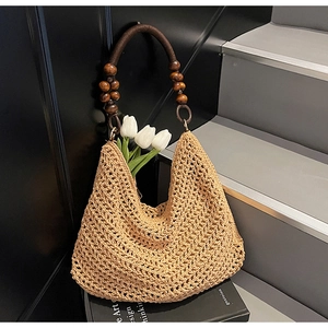 Detail of hand-woven tote bag with dark round wooden beads and brown rope handles