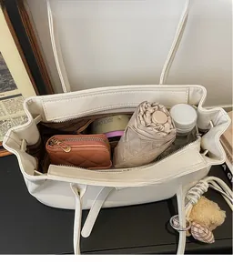 Detail view of white tote bag interior with umbrella, wallet and bottle for high capacity