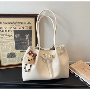 Détail d'un sac cabas blanc crème avec un charmant ours en peluche et un nœud décoratif