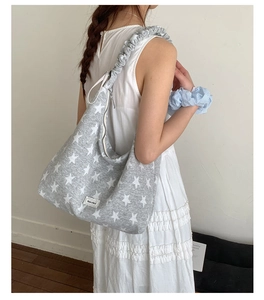 Detail of grey star pattern knit tote bag with ruffled ruched shoulder strap design