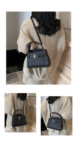 Détail du sac à main en cuir noir avec boucle dorée en C et poignée élégante