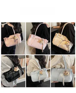 Detailed back view of a glossy leather tote bag with a cute bear charm and tassel