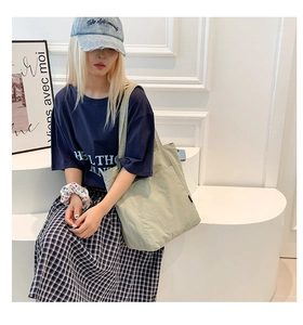 Light green canvas tote bag with side pocket shown in a casual lifestyle setting