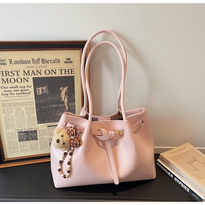 Détail du sac cabas en cuir rose avec boucle décorative et pendentif ours mignon