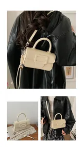 Chic cream leather crossbody bag with square buckle decoration and top handle detail