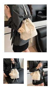 Close-up of white drawstring bucket bag with ripple texture and plush dog pendant