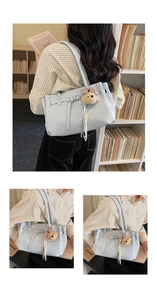 Close-up of light blue glossy tote bag featuring a decorative buckle and plush bear charm
