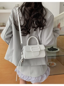 Elegant white square crossbody bag with tassel and magnetic buckle shown on model