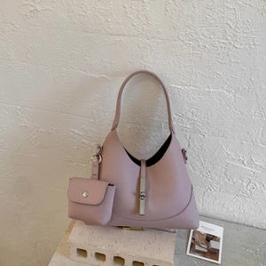 Detail view of pink pebbled leather shoulder bag with silver clasp and mini pouch accessory