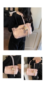 Detail view of pink glossy PU leather tote bag with plush bear charm and tassels