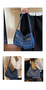 Detail of blue denim hobo bag featuring multiple functional zippers and metal button pockets