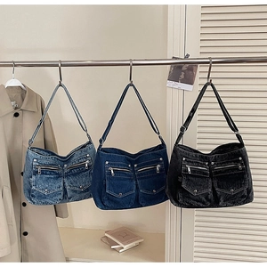 Detail of vintage denim tote bags in three washes with multiple functional pockets