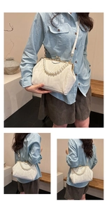 Detail of beaded pearl handle and white quilted fabric on elegant shell crossbody bag