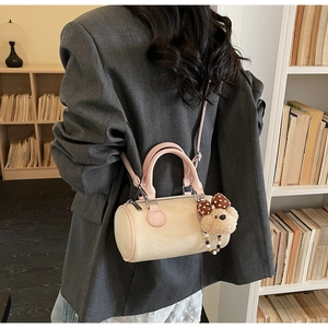 Retro cream and pink cylinder Boston bag with cute bear charm shown on a model
